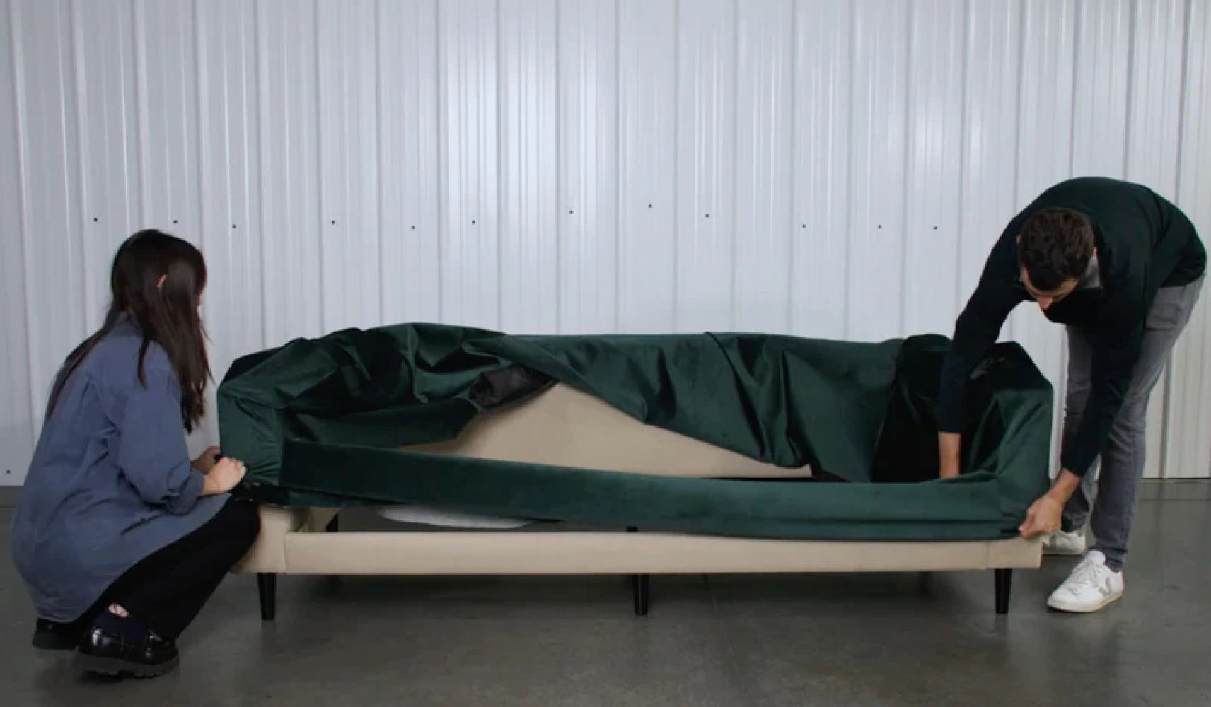 A young male and female recovering a sofa together