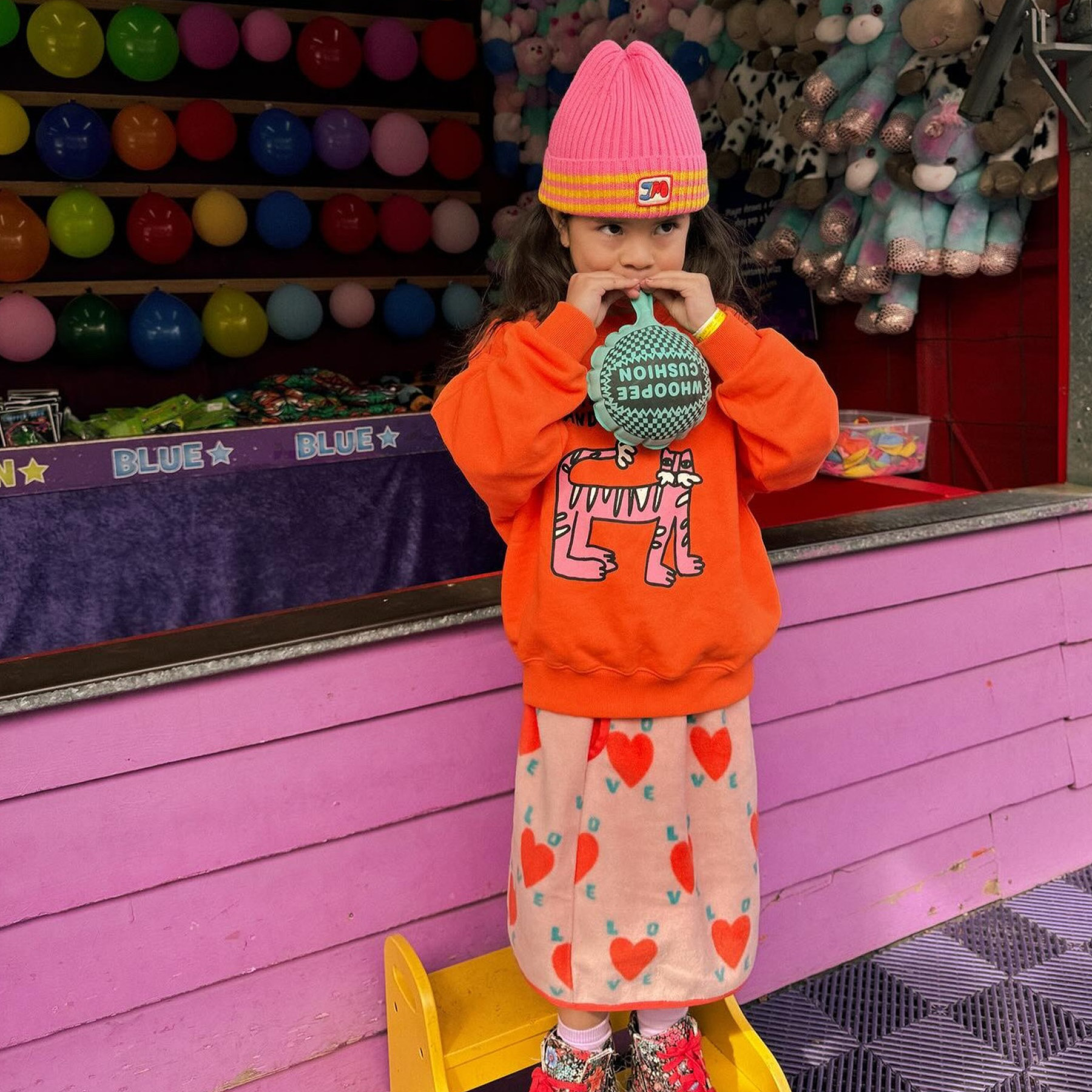 Young girl blowing up balloon