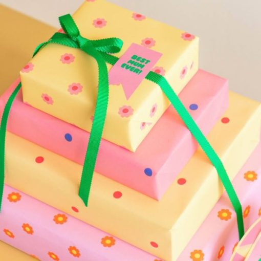 Stack of 4 pastel coloured presents stacked with a green ribbon around them
