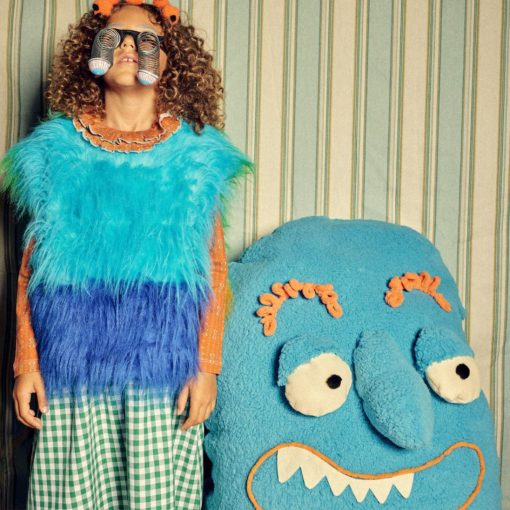 Little girl with play goggles on stood next to a toy monster